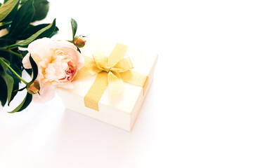 Beautiful bouquet of peonies and a white box with a yellow bow on a white background, flowering peonies