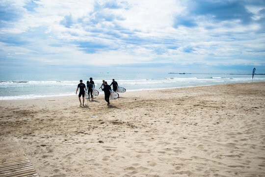 A Group Of Surfers At Sea.