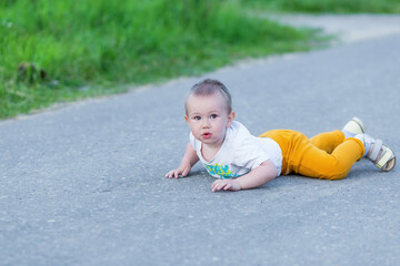 Fototapeta premium Cute toddler boy fell on park road