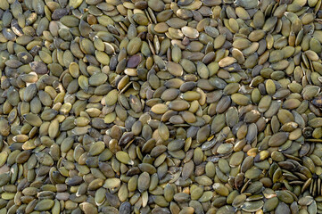 Zinc rich food backgrounds and nourishing vegetarian foods concept with full frame picture of many shelled pumpkin seeds with copy space