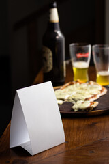 Blank QR card on wooden restaurant table with glass and bottle of wine