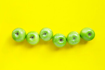 Fresh green apples on yellow background. Top view