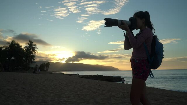 Woman taking photos on hawaiian beach Haleiwa, North shore, Oahu. Summer travel holidays vacation getaway on Hawaii, USA.