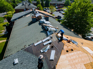 Construction worker on renovation roof the house installed new shingles © ungvar