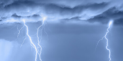 Naklejka na ściany i meble Lightning strikes between stormy clouds.