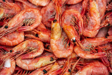 Lot of boiled-frozen wild shrimp with caviar cooked in sea water. Background of group small aquatic crustaceans. Prawn - Asian sea delicacy cuisine as an appetizer. Close-up flat lay of tasty seafood.