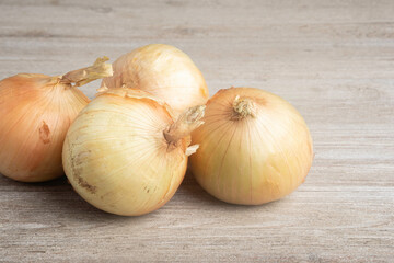 Four Sweet White Onions On A White Painted Panel Board