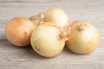 Four Sweet White Onions On A White Painted Panel Board