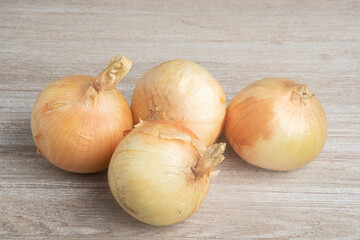 Four Sweet White Onions On A White Painted Panel Board