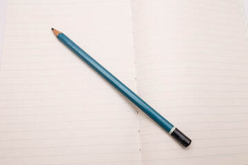 Open notebook on white background with pencil and rubber