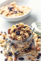 Jar of muesli with nuts, almonds grapes and dried fruits - closeup
