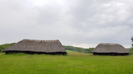Fototapeta na wymiar Old peasant Ukrainian house or barn in the summer with a thatched roof in the village. Pirogovo Museum in the open air of different regions of Ukraine.