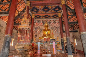 Fototapeta premium view of golden seated buddha statue in buddhist temple, Thai Lur style art 13th. Century., Wat Nong Bua, Tha Wang Pha District, Nan, northern of Thailand.