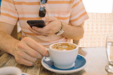 Close up of man taking photo of breakfast at cafe on sunny day.