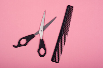 scissors and comb on a pink background, hairdresser tools.