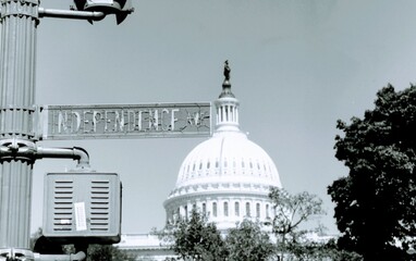 Faded and cracked Independence Ave. sign in Washington D.C. overlooking U. S. Capitol Building