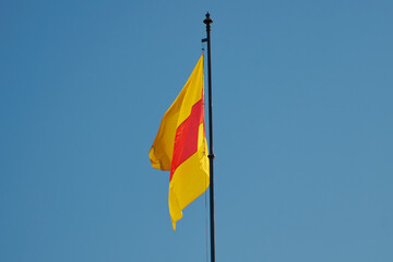 Close-up of red and yellow flag of Baden (Germany) with sky background