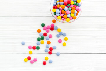 Colorful sweets on white wooden desk from above