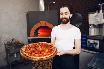 Chef in the kitchen. Man prepares pizza