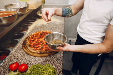 Chef in the kitchen. Man prepares pizza