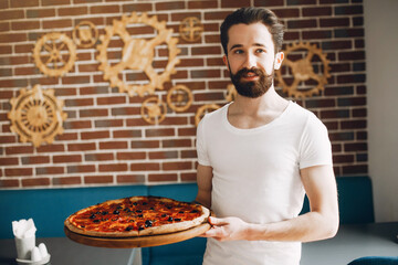 Chef in the kitchen. Man prepares pizza