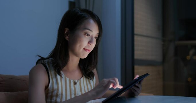 Woman use of tablet computer at home in evening