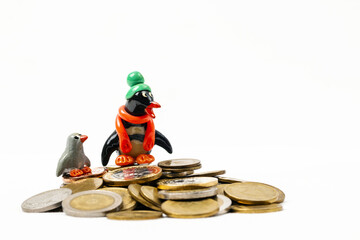 A coins mountain's  with two penguins standing on top and white background 