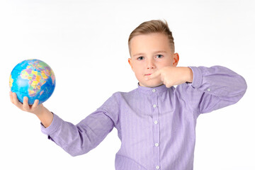 Playful young caucasian school boy holding a globe on white studio background.Boy is surprised shows at globe laughing