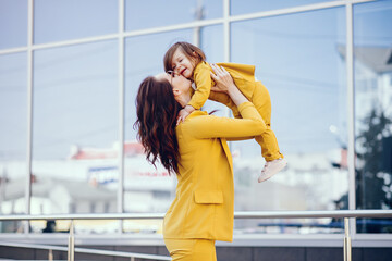 Beautiful girl in a summer city. Lady with shopping bags. Mother with daughter in stylish clothes