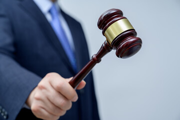Male businessman holding a gavel in hand. justice and auction concept.