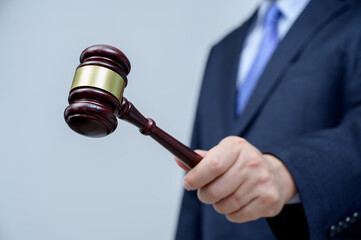 Male businessman holding a gavel in hand. justice and auction concept.