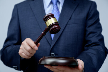 Male businessman holding a gavel in hand. justice and auction concept.