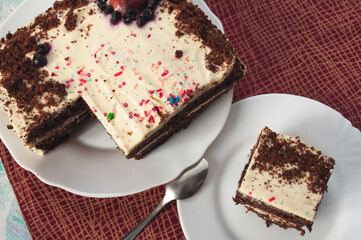 Sponge cake with cream on a white plate, top view