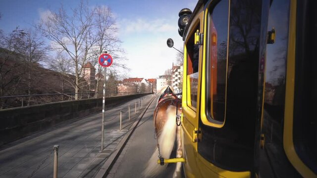 Side view of Old yellow stagecoach with horses rides on the streets of old town