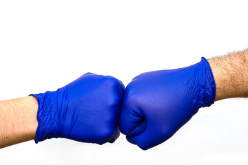 hands in blue protective surgical gloves greet each other with their fists.