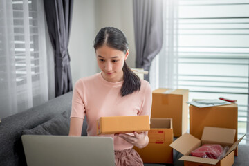 Happy beautiful girl who works at home About Online Business, Prepare goods to customers.