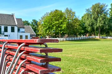 Empty sports field with a pile of red benches during the coronavirus pandemic. Image with selective focus.