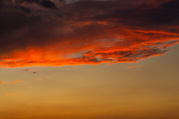Black thunderclouds at sunset. Bright orange sunset and dark clouds. Storm sky