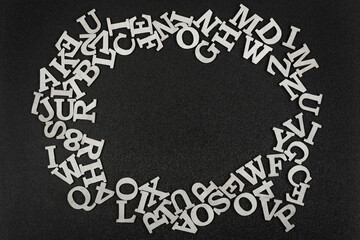 White Latin letters in form of round frame on black background. Copy space. Template. Mockup