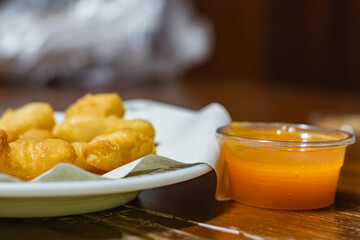 Fried dough sticks are placed on white paper on the plate and near has yellow egg jam. Fried dough stick also called 