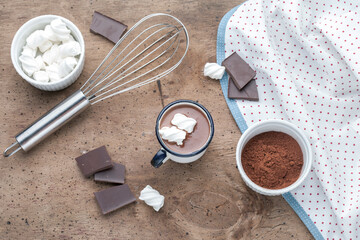Metal mug of hot chocolate with marshmallows on wooden background.