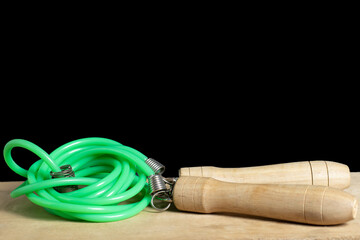A skipping rope is on wood the table with isolated background. Sport at home.