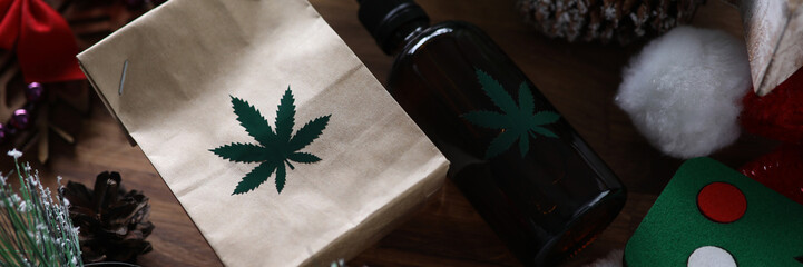 Eco paper pack with green marijuana sign with christmas symbol background closeup. Legal drug concept