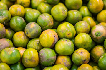 Many oranges are placed in basket at market. Healthy concept.