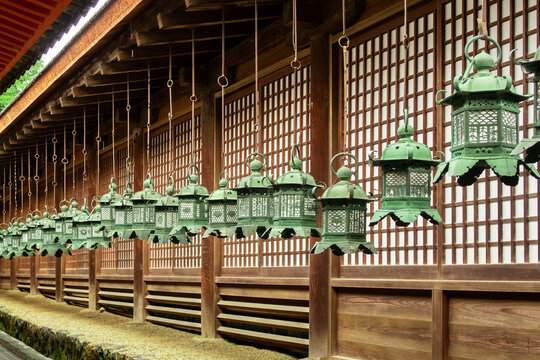 Row of decorative traditional japanese green lanterns hanging in wooden buddhist temple in Nara, Japan.