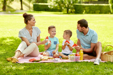 family, leisure and people concept - happy mother, father and two little sons having picnic and...