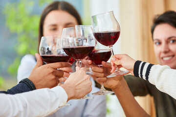 Gruppe Freunde beim Anstoßen mit Glas Rotwein