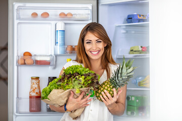 Healthy eating woman grabbing vegetables from the fridge. Healthy eating woman. Woman looking...
