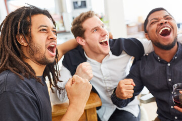 Befreundete Männer jubeln zusammen beim Fußball schauen © Robert Kneschke