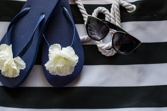 Women Flip Flops And Sunglasses On Black And White Beach Bag